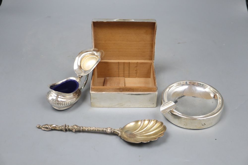A silver cigarette box, a silver mounted ashtray, a silver spoon and a plated mustard.
